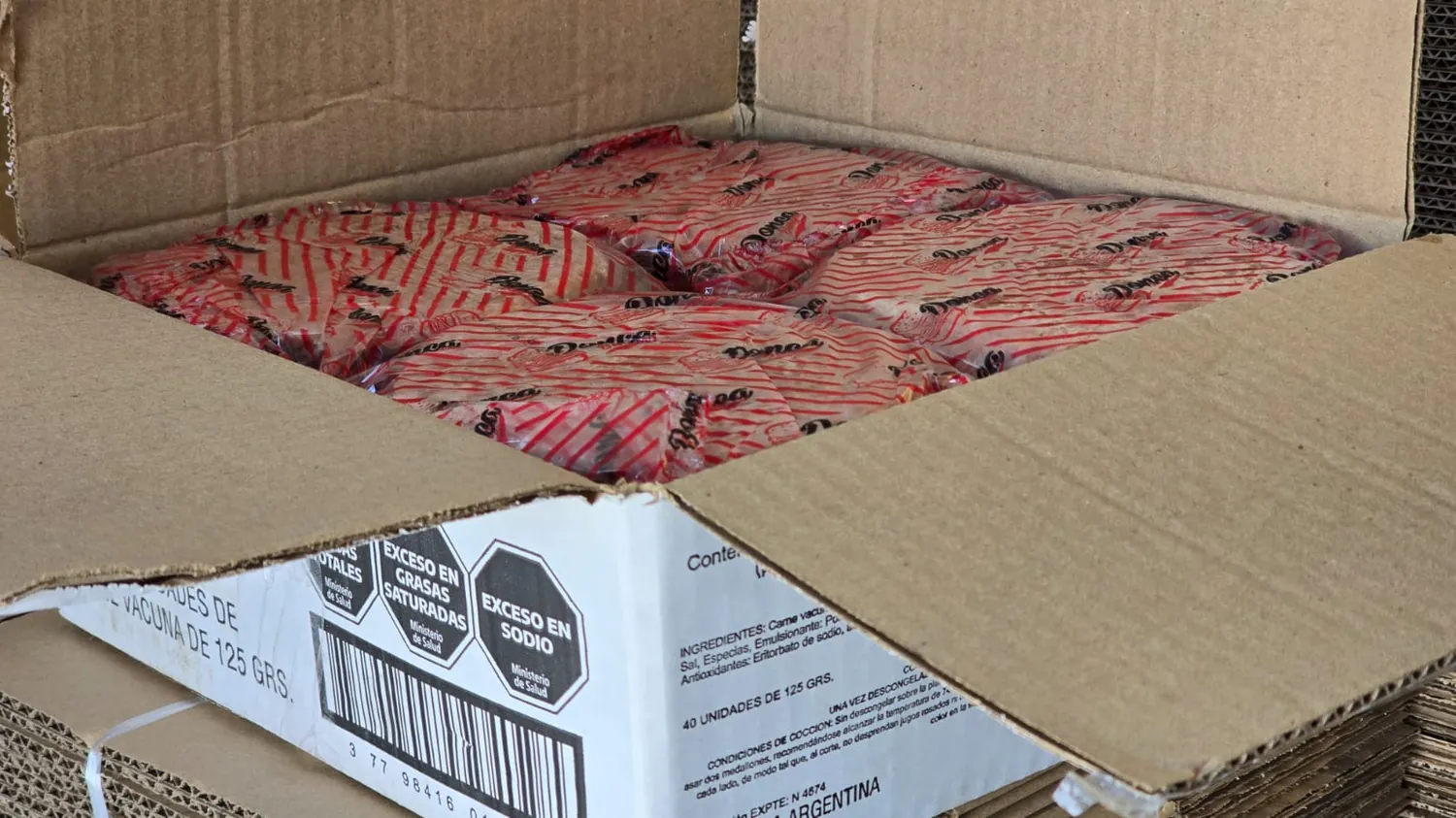 Caja abierta de medallones de hamburguesa envasados New Burger